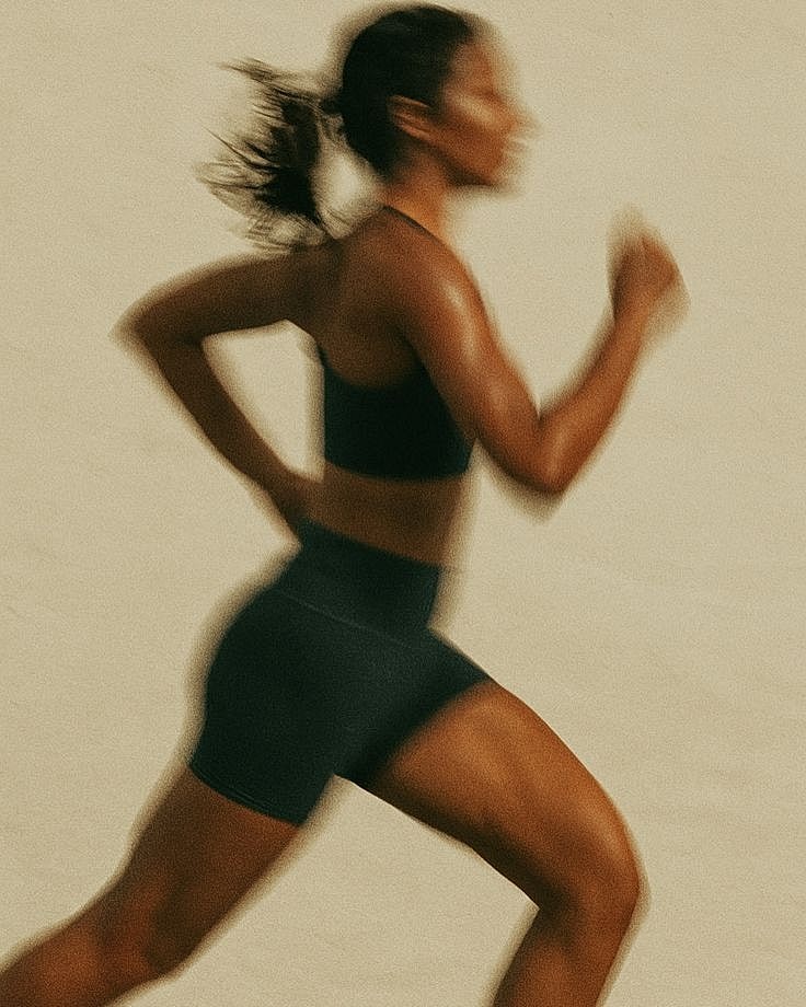 Woman enjoying sunny beach day, smiling blissfully.